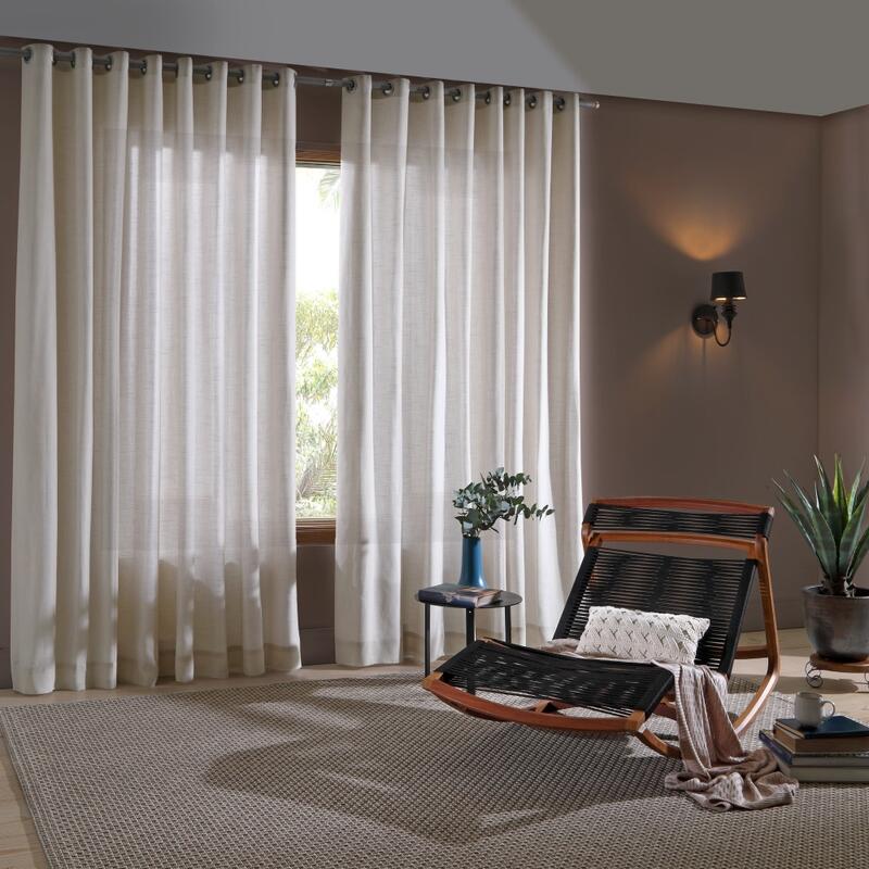 Sala com cortinas de linho branco e cadeira de balanço