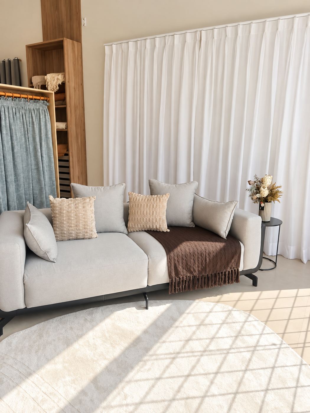 Sala do showroom com cortina branca e sofá